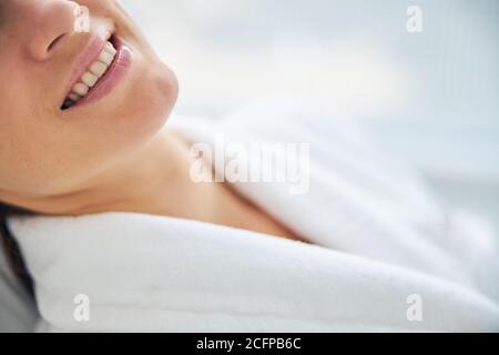 Merry female patient in a terry bathrobe Stock Photo