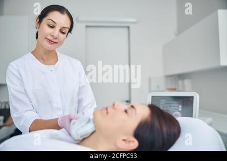 Doctor looking at her patient during a cosmetic procedure Stock Photo