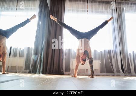 Pole dance trainer doing acrobatic elements in fitness class Stock Photo
