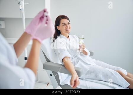 Smiling woman with a catheter in her vein looking away Stock Photo