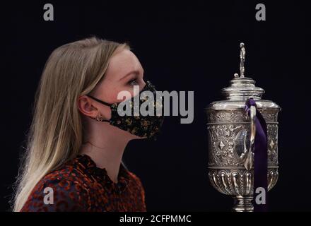 Laurel Kemp of Bonhams with the oldest surviving FA Cup trophy during a preview of the Sporting Trophies Sale at which will take place as Bonhams New Bond Street saleroom on September 29. The silver two-handled cup, estimated at GBP 700,000 -900,000, was made by Vaughton and Sons of Birmingham in 1896, and was presented to the FA Cup winning teams between 1896 and 1910, including Manchester United, Manchester City, Everton, Newcastle United and Tottenham Hotspur. Stock Photo