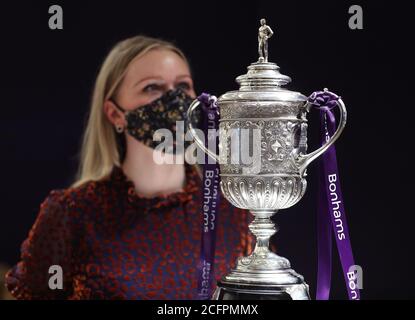 Laurel Kemp of Bonhams with the oldest surviving FA Cup trophy during a preview of the sporting Trophies Sale at which will take place as Bonhams New Bond Street saleroom on September 29. The silver two-handled cup, estimated at GBP 700,000 -900,000, was made by Vaughton and Sons of Birmingham in 1896, and was presented to the FA Cup winning teams between 1896 and 1910, including Manchester United, Manchester City, Everton, Newcastle United and Tottenham Hotspur. Stock Photo