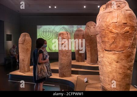 Visitors wearing face mask due to the COVID-19 coronavirus pandemic view human shaped coffins from the 13th century BCE found in Deir el Balah Gaza strip displayed at the Archeology Wing of the Israel Museum in West Jerusalem Israel Stock Photo