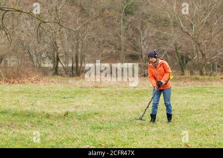 Search with a metal detector in nature, on the background of a fire ...