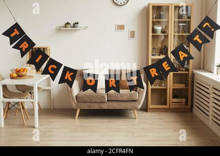 Horizontal no people shot of modern room interior with Trick or Treat lettering garland in it prepared for Halloween party Stock Photo