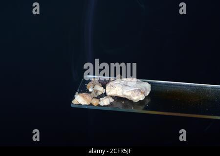 Closeup shot of benzoin pieces on a glass Stock Photo