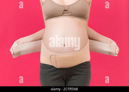 Close up of pregnant woman wearing pregnancy corset against backpain at  gray background with copy space. Orthopedic abdominal support belt concept  Stock Photo - Alamy