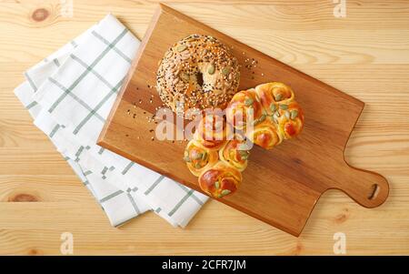 Top view of assorted breads on the wooden breadboard with kitchen cloth Stock Photo