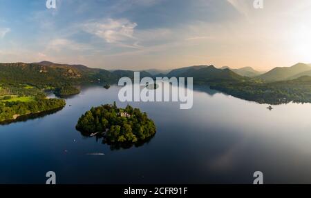 Aerial panorama of sunset next to a beautiful, flat calm lake surrounded by hills (Derwent Water, Keswick, England) Stock Photo