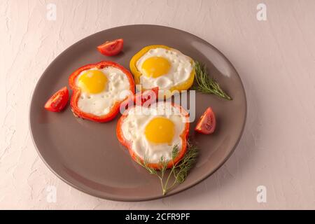 Scrambled eggs fried in rings of Bulgarian pepper with tomatoes and herbs. Stock Photo