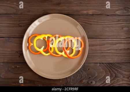 Scrambled eggs fried in rings of Bulgarian pepper with tomatoes and herbs. Stock Photo