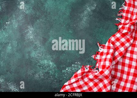 Red checkered tablecloth on green background Stock Photo