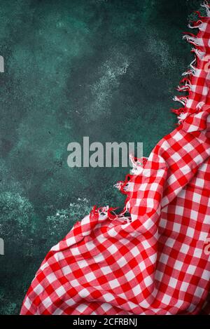 Red checkered tablecloth on green background Stock Photo