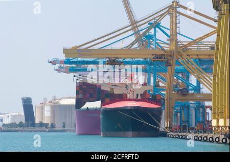 Green transport ship at the pier unloading containers Stock Photo - Alamy