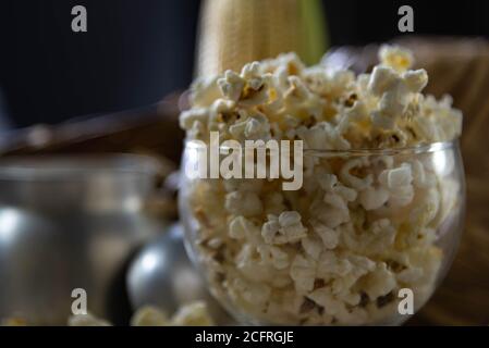 Glass bowl with popcorn. Blurred background. Delicious. Culinary delicacy. The perfect popcorn can be made in several ways: in the microwave, in the p Stock Photo