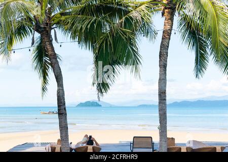 Man relaxing laying down on beach, ocean view Stock Photo