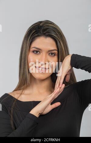 closeup of beauty latin woman face, with long hair and black diver, posing with her hands, studio Stock Photo
