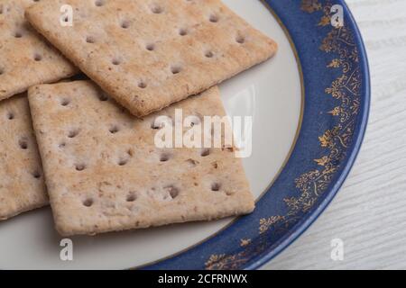 close up of various cookies on a blue and white plate that have gold details, studio Stock Photo