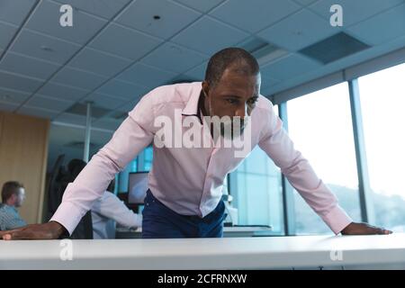 Senior businessman leaning on table at modern office Stock Photo