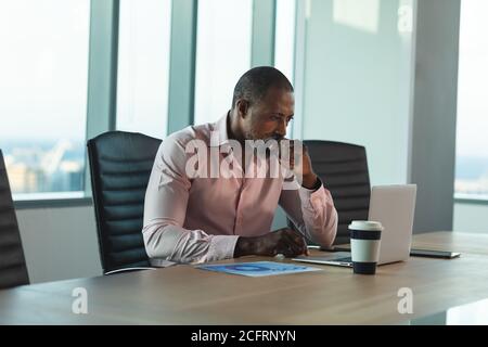 Senior businessman using laptop in modern office Stock Photo