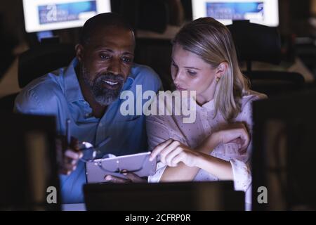 Senior businessman discussing with young businesswoman over a digital tablet Stock Photo