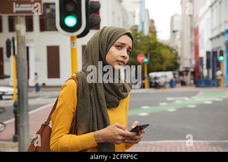 Woman in hijab using smartphone on the street Stock Photo