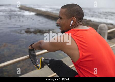 Man with prosthetic leg performing stretching exercise on the promenade Stock Photo
