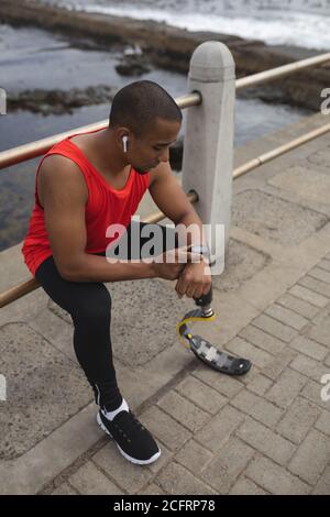 Man with prosthetic leg performing using smartwatch on the promenade Stock Photo