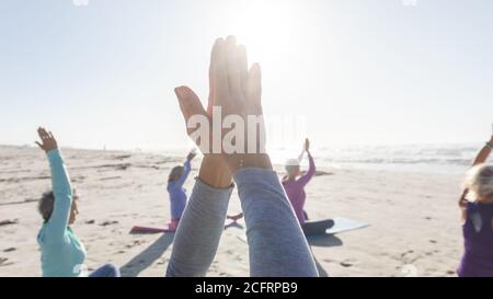 Group of woman practicing yoga on the beach Stock Photo