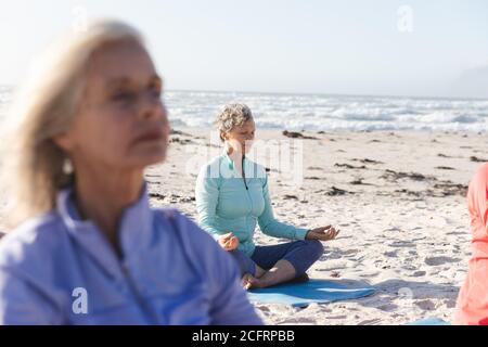 Woman practicing yoga on the beach Stock Photo
