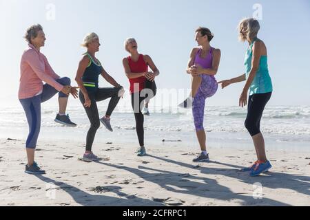 Group of woman performing stretching exercise at the beach Stock Photo