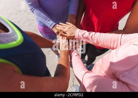 Mid section of group of woman stacking hands together at the beach Stock Photo