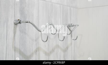 Metal adhesive hooks on gray background. Towel hangers Stock Photo