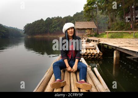 Travelers thai women travel visit and sitting relax on rowing bamboo rafts on Pang Ung lake in Pang Oung or Switzerland of Thailand in authentic Chine Stock Photo