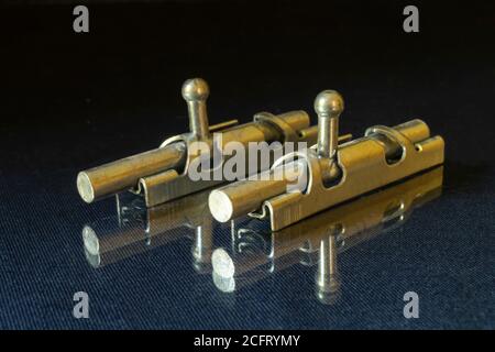 The Metallic latch on glass table on black background. Bolt for closing door in premises Stock Photo