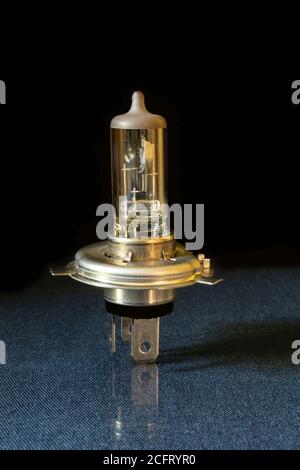 The Halogen lamp for headlights of the car on black background. The Glass flask with metallic body. Spare parts for repair Stock Photo