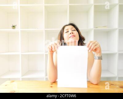 Beautiful woman smiling happy against white background. Asian woman holding a paper. Stock Photo