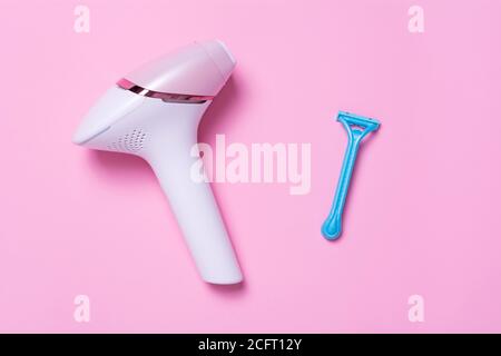 Blue razor and photoepilatoron on a pink background. View from above. The concept of choosing a method of hair removal.