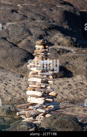 Cairn like pyramid made out of driftwood on an Oregon beach, vertical Stock Photo