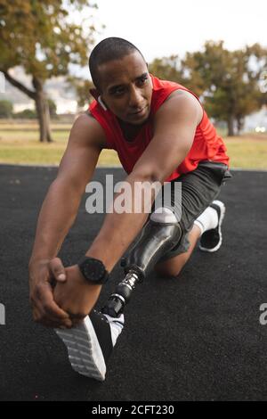 Man with prosthetic leg performing stretching exercise in the park Stock Photo