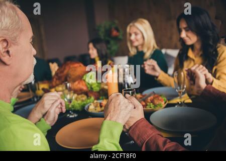 Portrait of nice attractive peaceful calm religious family sitting around table holding hands praying eating homemade festal lunch meal dish at modern Stock Photo