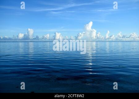 Calm deep blue sea and horizon of puffy white clouds in the tropical Mariana Islands, Micronesia Stock Photo