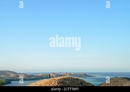 a tourists enjoying the view from the top of the Sylvia Hill, Labuan Bajo, Flores Island, East Nusa Tenggara, Indonesia Stock Photo