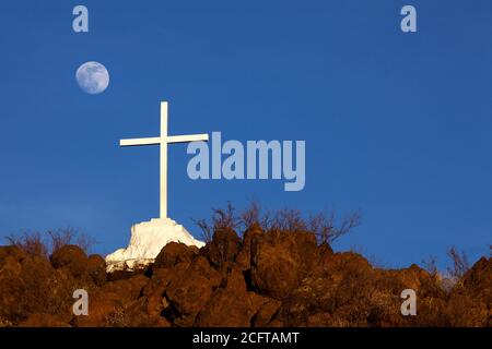 Tohono O'Odham Indian Reservation  AZ / JAN  Moonrise beyond the hilltop and cross overlooking Mission San Xavier del bac. V2 Stock Photo
