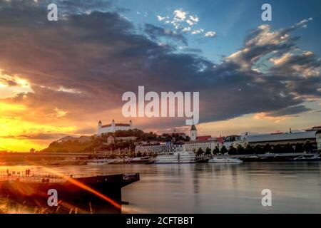 view of Bratislava castle during golden hour with beautiful sunset on river Danube, Slovakia Stock Photo