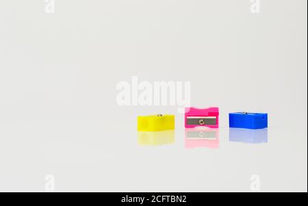 Nice pencil sharpeners of different colors on plain background Stock Photo
