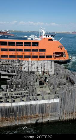 Staten Island Ferry docked at St. George Terminal in Staten Island with wooden pressure treated pillars Stock Photo