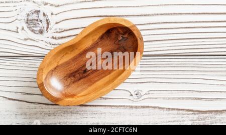 Small polished rosewood bowl on white boards desk, closeup view from above Stock Photo