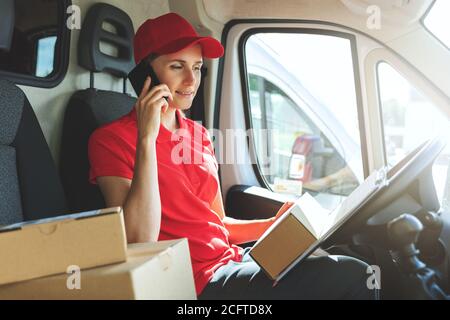 delivery woman talking on mobile phone in van Stock Photo