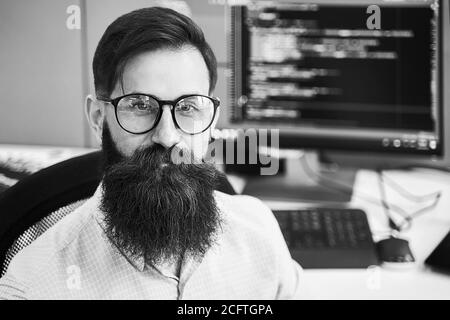 Closeup portrait of a serious computer programmer developer working in IT office, sitting at desk and coding a project in software development company Stock Photo